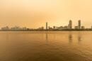 The Boston skyline along the Charles River as seen around noon on Wednesday as wildfire smoke from Canada creates a yellow haze. (Jesse Costa/WBUR)