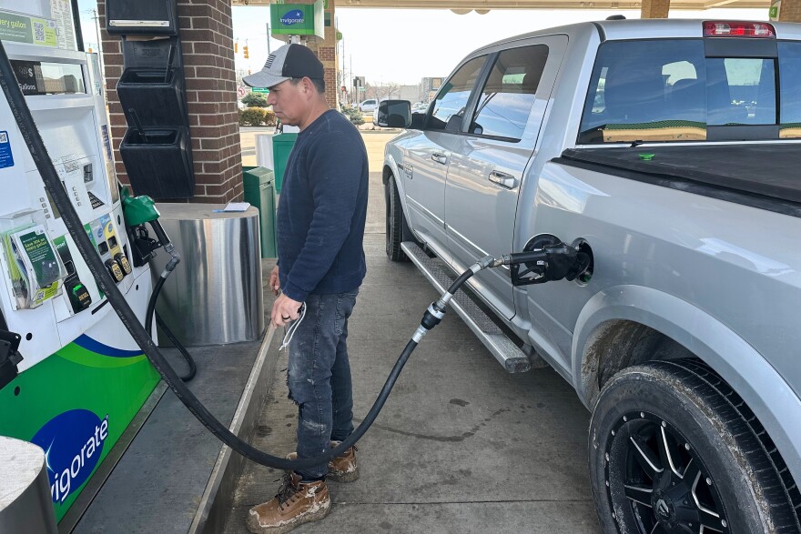 Josue Hernandez, 35, pumps gas into his work pickup truck.
