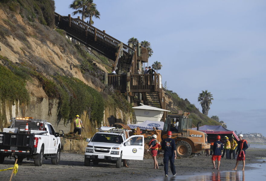 Lifeguards and search and rescue personnel work at the site of a cliff collapse at a popular beach on Aug. 2, 2019, in Encinitas, California. (Denis Poroy/AP)