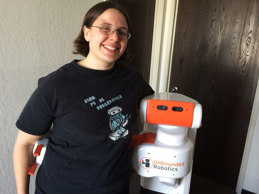 Melonee Wise the CEO and co-founder of Unbounded Robotics. She is standing with the company's robot, the UBR-1.