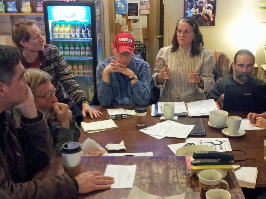Members of the Saratoga Peace Alliance discuss plans for a street action they plan to stage at the city's upcoming gun show.
