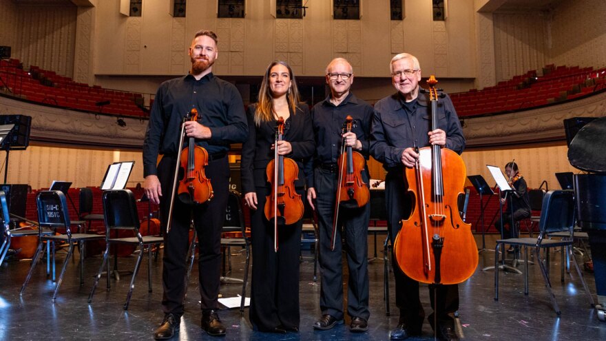 Musicians pose on stage for photo.