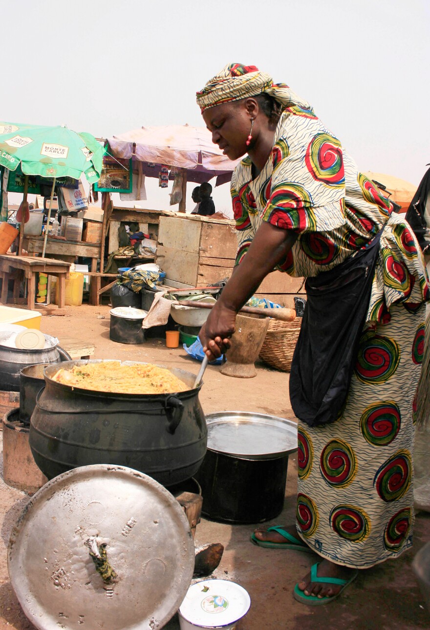 A food vendor in Kano, Nigeria, prepares jollof rice outdoors in an iron pot. When it comes to jollof, my Nigerian friend Ronke Onadeko argues, "the taste of perfection is smoke-flavoured."