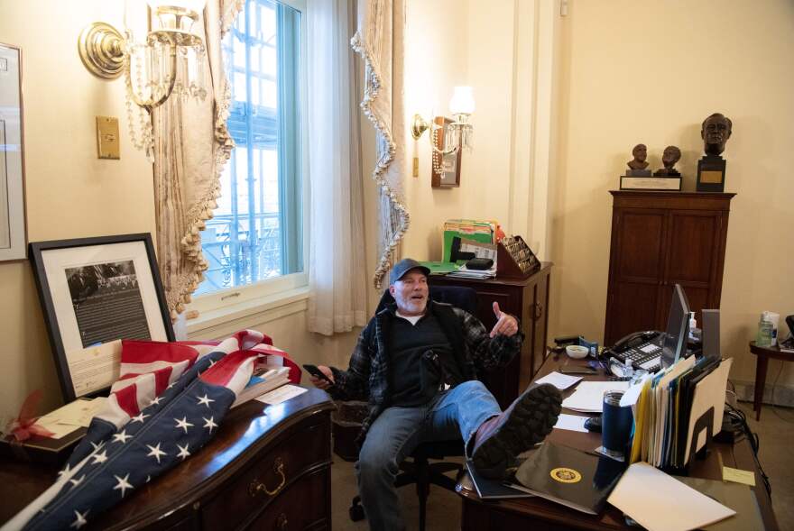 A rioter sits inside the office of House Speaker Nancy Pelosi inside the U.S. Capitol.
