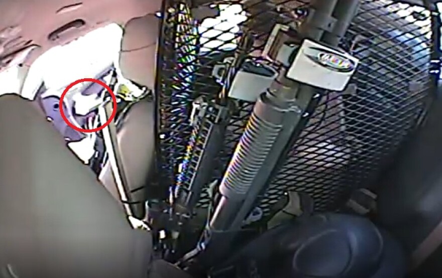 Video from inside of Morphis' squad car shows a hand throwing an object appearing to be a bag of drugs in the backseat.