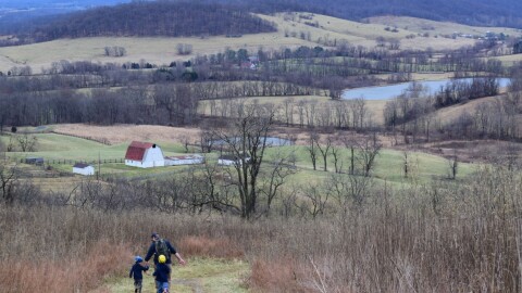 A man is running in a field with two children.S