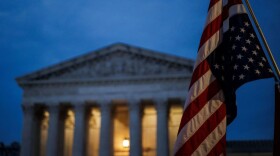 An abortion rights activist flies an upside down US flag, the international sign of distress, outside of the US Supreme Court during a protest in Washington, DC, on June 26, 2022, two days after the US Supreme Court scrapped half-century constitutional protections for the procedure. - Elected leaders across the US political divide rallied on June 26 for a long fight ahead on abortion -- state by state and in Congress -- with total bans in force or expected soon in half of the vast country. (Photo by Samuel Corum / AFP) (Photo by SAMUEL CORUM/AFP via Getty Images)