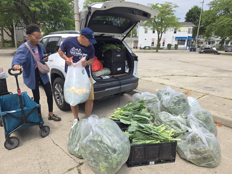 Volunteers cart donated vegetables to a refrigerated shed at All People's Church in Milwaukee's Harambee neighborhood.