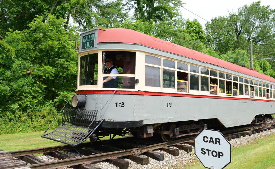 A historic trolley car carrying passengers down a track