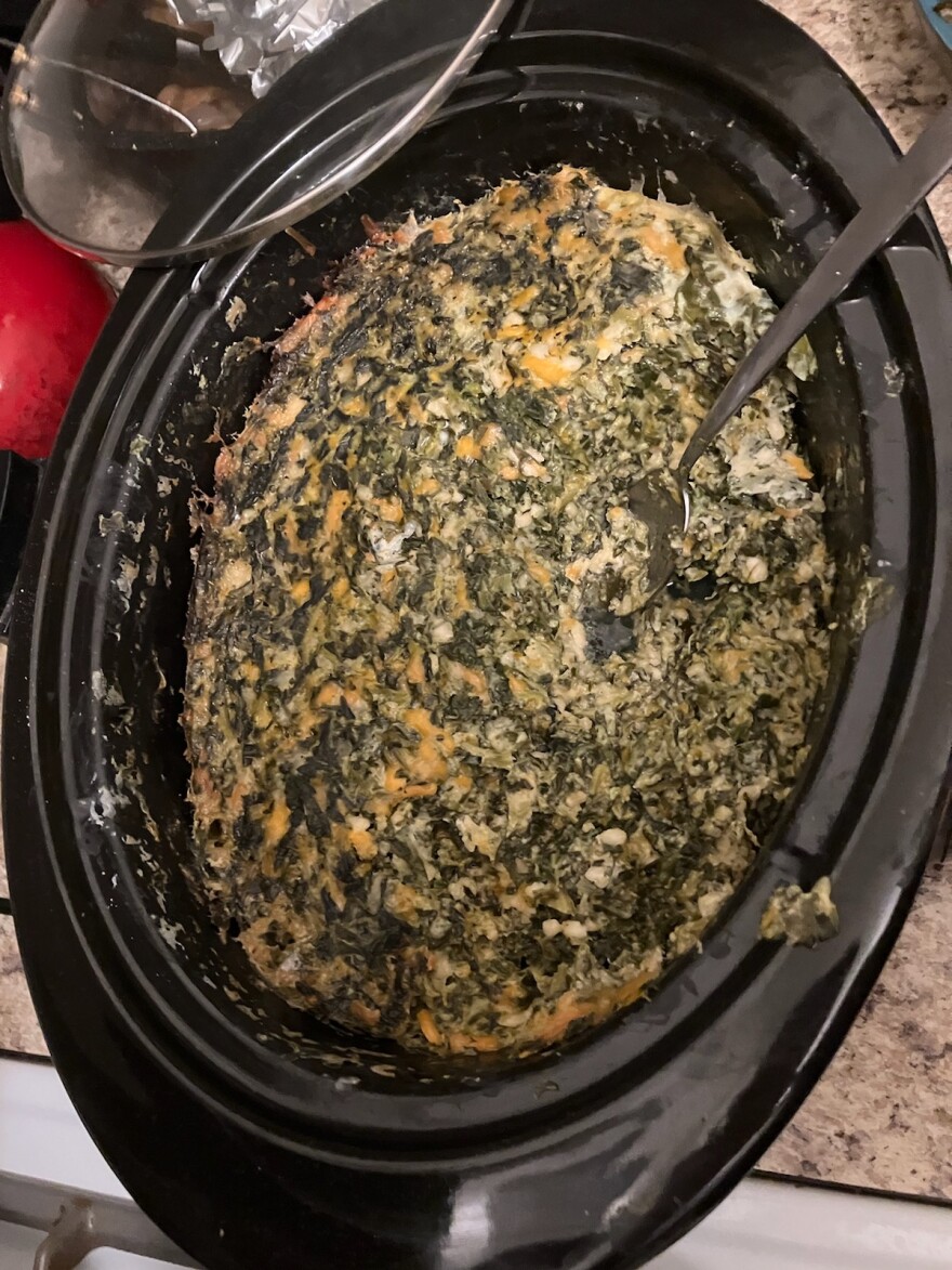 Spinach souffle in a black casserole dish.
