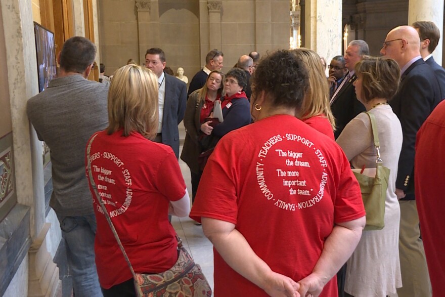 Teachers dressed in red joined other education advocates at a school funding meeting in the statehouse.