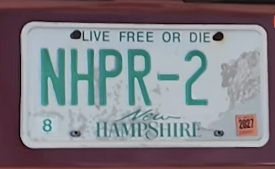 A red car with a New Hampshire license plate that reads "NHPR-2."
