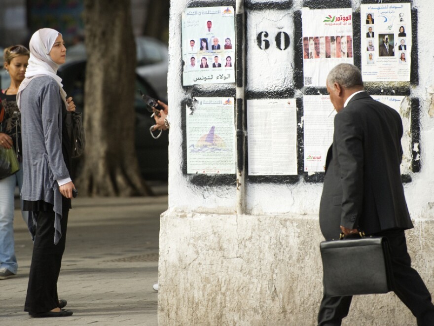 <p>A Tunisian woman in Tunis looks at posters presenting political candidates, on Oct. 20. Some Tunisians fear that if popular Islamist parties take power, they will seek to put their stamp on this moderate, secular state.</p>