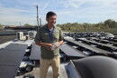 Sustainergy CEO Flequer Vera shows off the employee-owned company's solar array on its roof. The 20-employee company installs solar panels and energy efficiency material for homes and businesses. Vera is also vice president of Co-op Cincy, which advocates for employee ownership.