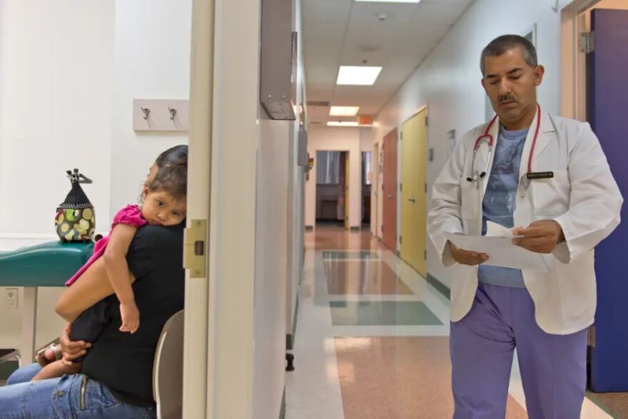 Yesenia Alvarado held her daughter, 2-year-old Melanie Almaraz, a Medicaid patient, during a 2013 visit to see Dr. Alberto Vasquez for treatment of a fever at Su Clinica Familiar in Harlingen.