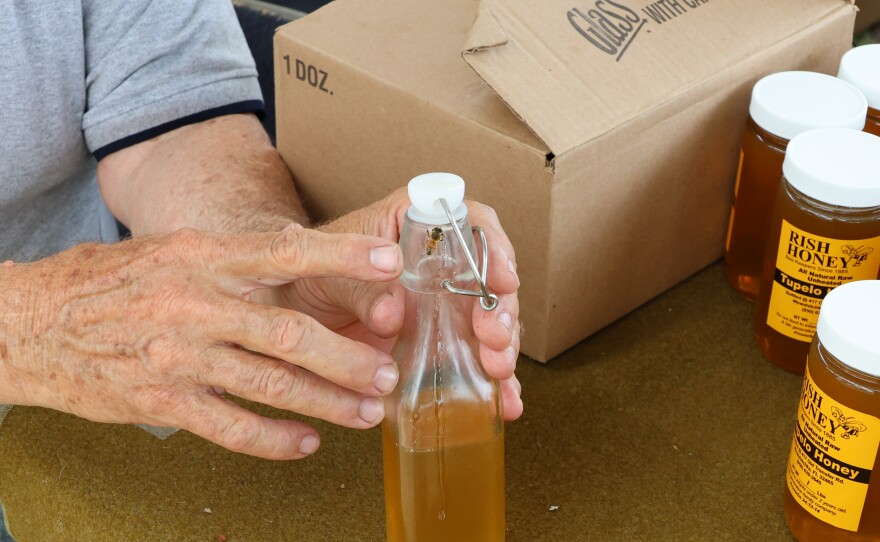 A bee lands on a bottle containing honey.