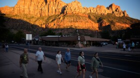 People walk, Wednesday, Oct. 1, 2025, in Springdale, Utah near the entrance to Zion National Park. (AP Photo/John Locher)