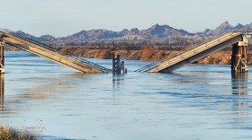 A cement and wood bridge broken in the middle and fallen into the water