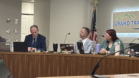Traverse City city attorney Dan Kelly answers questions about the prowling ordinance in a city commission meeting while seated next to City Manager Benjamin Marentette and Mayor Amy Shamroe. (IPR News / Maxwell Howard)