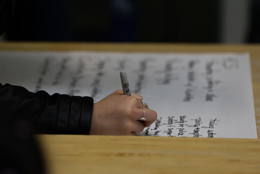 Students write down their ideas during one of the group discussions