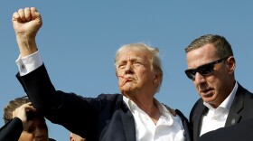 Republican presidential candidate former President Donald Trump pumps his fist as he is rushed offstage during a rally on July 13, 2024 in Butler, Pennsylvania.