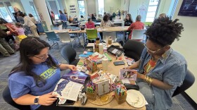 Emily Gallagher (left), with Keep Norfolk Beautiful, and Alora Bess make journals out of recycled paper at the UpCycling Festival in Norfolk on Saturday, Nov. 15, 2025.