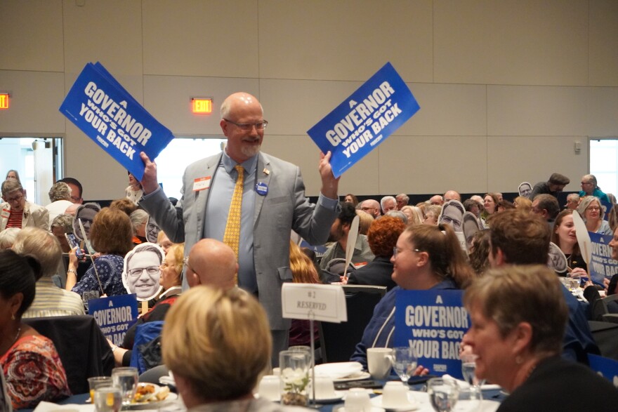Mark Higgins (left, standing) handed out campaign signs for Gov. Josh Shapiro at Saturday's Centre County Democrat's Breakfast. Higgins is the Chair of the Centre County Commissioners. 