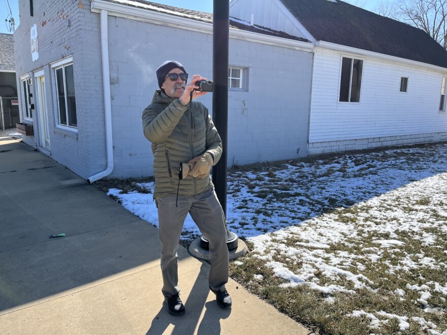 Consultant Mark Fenton stops during a walk around the Levee District of East Peoria to take a picture of an intersection.