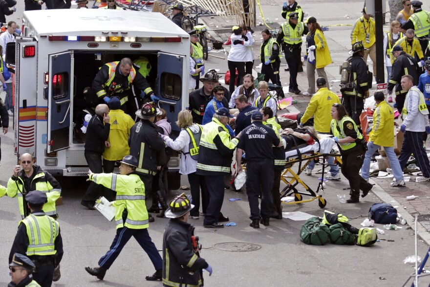 Amelia Nelson, next to the ambulance in the blue and white jacket, aids injured people at the finish line of the 2013 Boston Marathon on April 15, 2013.