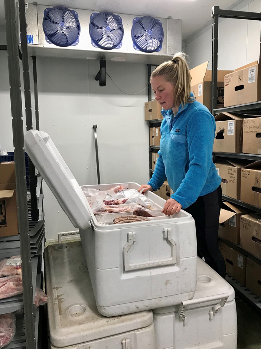 Kira Jarosz works in the freezer at Black Dog Farm in Livingston
