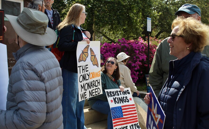 Two protestors sitting on the steps outside of Thalian Hall.