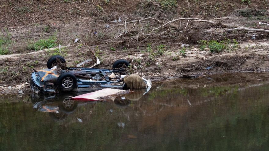 An overturned car sat on the banks upstream of the Old Fort Finishing Dam.