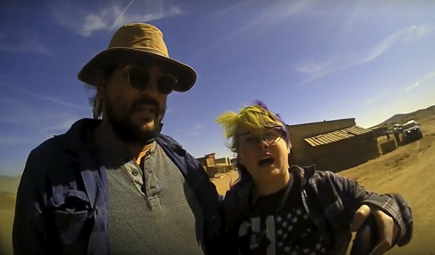 In this screen grab from lapel camera video provided by the Santa Fe County Sheriff's Office, movie set armorer Hannah Gutierrez-Reed, right, speaks with a sheriff’s deputy as a colleague stands next to her on the set of the western move “Rust,” shortly after the fatal shooting of cinematographer Halyna Hutchins by Alec Baldwin during a rehearsal, Oct. 21, 2021, in New Mexico. A judge will consider allegations of due process violations in the prosecution of Gutierrez-Reed, who is accused of involuntary manslaughter and evidence tampering in Hutchins' death, at an online court hearing scheduled Tuesday, Aug. 1, 2023. Charges against Baldwin in connection with the shooting were dismissed in April. (Santa Fe County Sheriff's Office via AP)