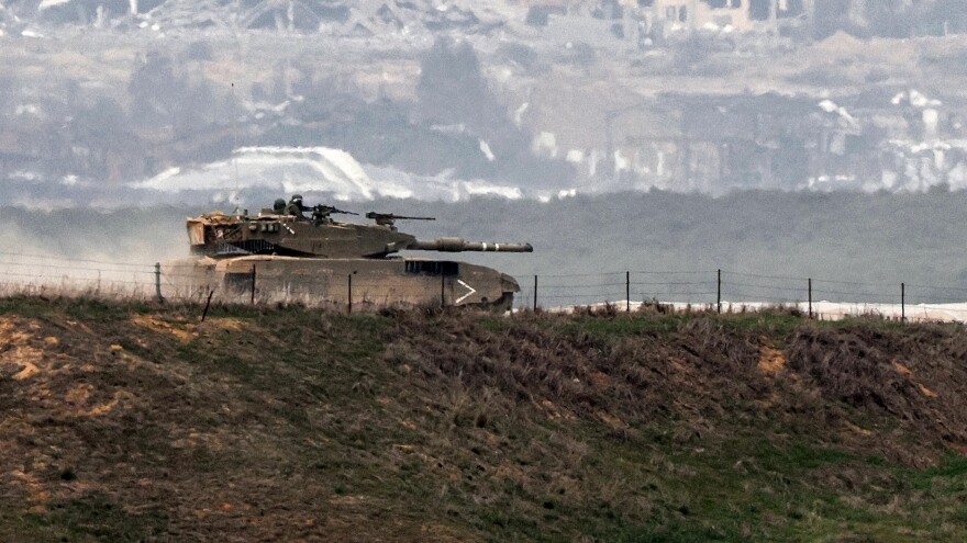 An Israeli battle tank moves along the border between the Gaza Strip and southern Israel on Wednesday as battles between Israel and Hamas continue.
