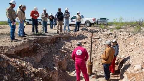 A crowd gathers around an excavated well on Antina Ranch.