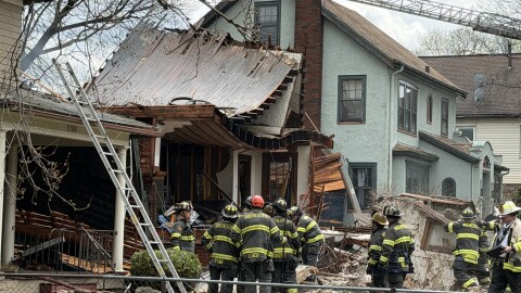Rochester firefighters work to extinguish remaining hot spots after an apparent house explosion on Tuesday, April 14, 2026, destroyed a 2 1/2-story rental home at 1128 Lake Ave.