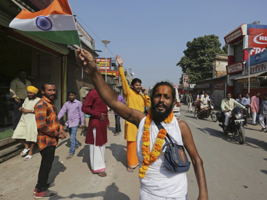 A Hindu devotee waves an Indian national flag and celebrates a verdict in a decades-old land title dispute between Muslims and Hindus, in Ayodhya, India, on Saturday.