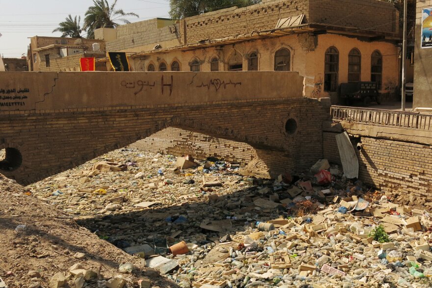 A canal along Basra's Shanashiel Street is covered in floating trash. The city was known as the Venice of the Middle East because of its beauty and canals. Decades of neglect have left it in ruins.
