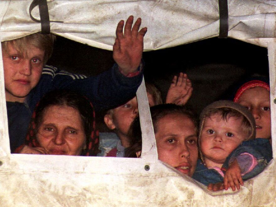 Bosnian refugees peer out from a U.N. truck in March 1993 after being evacuated from Srebrenica.