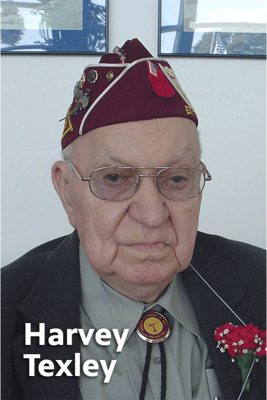 Elderly Harvey Texley wearing glasses, a gray button-up shirt with a bolo tie, a black jacket with a red carnation in the lapel, and a burgundy veteran's cap