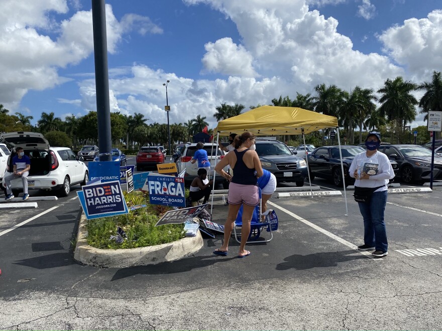 Different organizations and campaign groups stood out in the parking lot at FIU. Roz Roman (far left) gave out campaign pamphlets to voters.