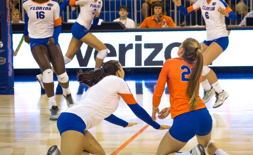 Živa Recek (left) and Nikki O'Rourker dig in an attemp to save the ball from touching the court's floor.