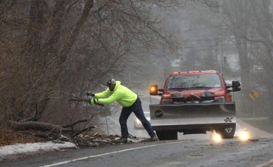 A Town of Perinton DPW worker clears fallen limbs on Garnsey Rd. Friday morning.