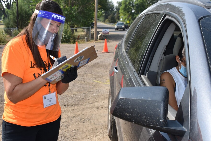 Lauri Dawn Kindness, left, helps a family participate in the U.S. Census as part of a campaign to increase Native American participation in the count during the pandemic, on the Crow Indian Reservation, in Lodge Grass, Mont. on Wednesday, Aug. 26, 2020. (Matthew Brown/AP)