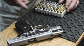 In this file image, the owner of a shooting range, prepares to load bullets in his 9mm semi-automatic handgun for a demonstration, Thursday, June 23, 2022, in New York.