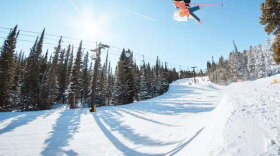 A skier jumps high up into the air going down a snowy run at the Eldora Mountain Ski Resort in Boulder County.