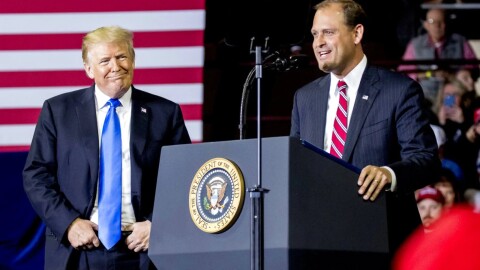 In this Oct. 13, 2018 photo, President Donald Trump, left, listens as Rep. Andy Barr, R-Ky., right, speaks at a rally at Alumni Coliseum in Richmond, Ky. The Lexington-area battle pits third-term Republican Rep. Andy Barr against Democrat Amy McGrath, a retired Marine fighter pilot. Trump won the 6th District by more than 15 percentage points in 2016. But with the help of carefully-shaped campaign ads that went viral, McGrath holds the edge on campaign fundraising.