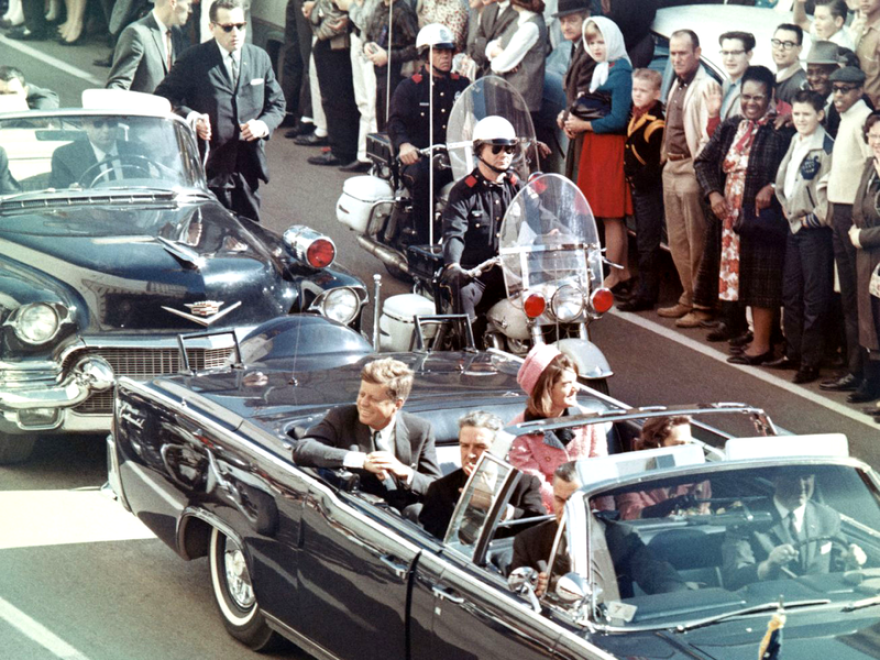 President John F. Kennedy in the motorcade where he was assassinated, with Texas Governor John Connally sitting in front of him.