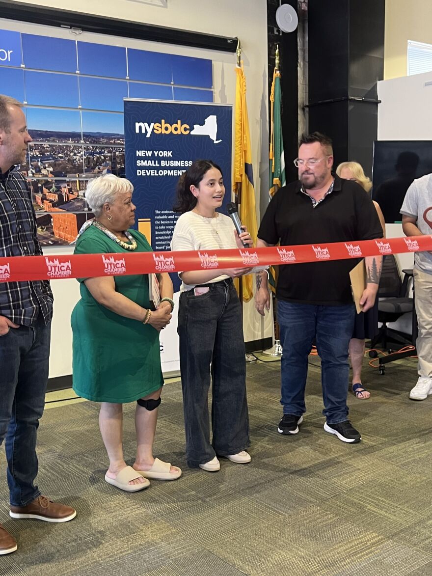 Pratiksha Bista, (center) a recent immigrant from Nepal has developed a mobile app to help small business owners track their expenses. She spoke at a ribbon-cutting ceremony in Utica on Thursday.