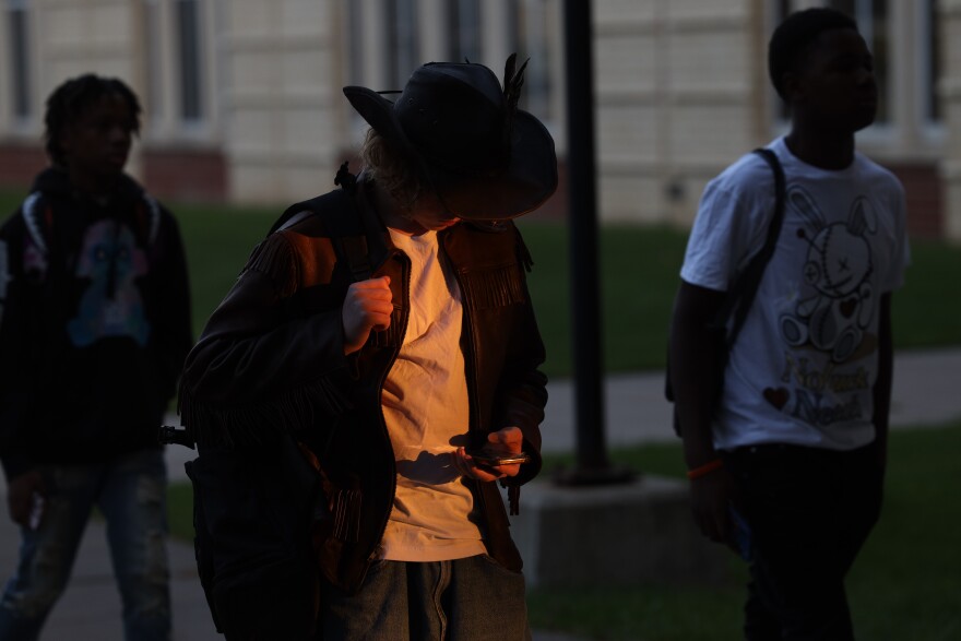 A studnets uses thier phone while waiting for school to start on the first day of School for the Rochester City School District, Thursday, September 5, at the new Loretta Johnson Middle School, on Genesee Street.